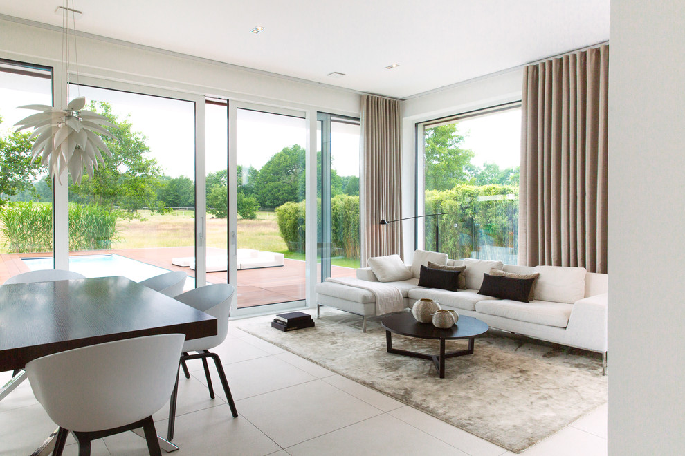 Mittelgroßes, Fernseherloses, Offenes Modernes Wohnzimmer ohne Kamin mit weißer Wandfarbe und weißem Boden in Hamburg