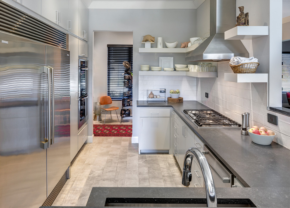 Inspiration for a mid-sized transitional galley porcelain tile open concept kitchen remodel with a single-bowl sink, open cabinets, gray cabinets, soapstone countertops, white backsplash, cement tile backsplash, stainless steel appliances and no island