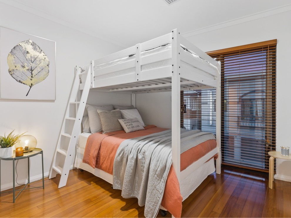 This is an example of a contemporary kids' bedroom in Perth with white walls, medium hardwood floors and brown floor.