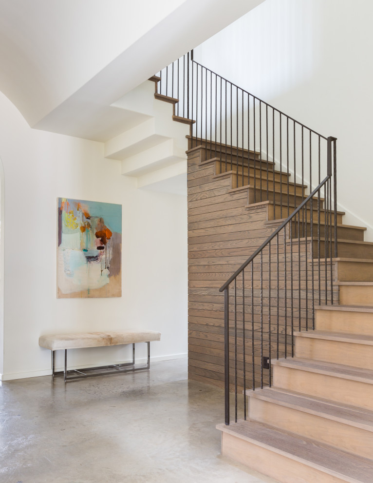 Design ideas for a large modern wood floating staircase in Houston with wood risers, metal railing and wood walls.