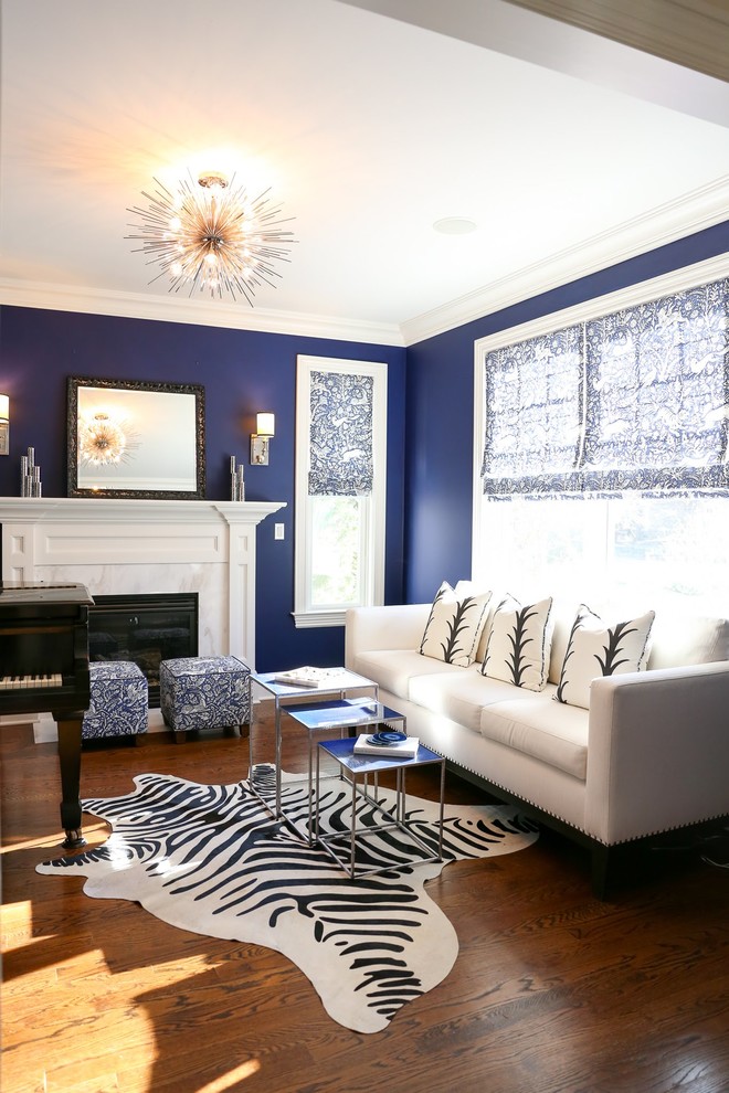 Inspiration for a transitional living room in New York with a music area, blue walls, medium hardwood floors, a standard fireplace and brown floor.