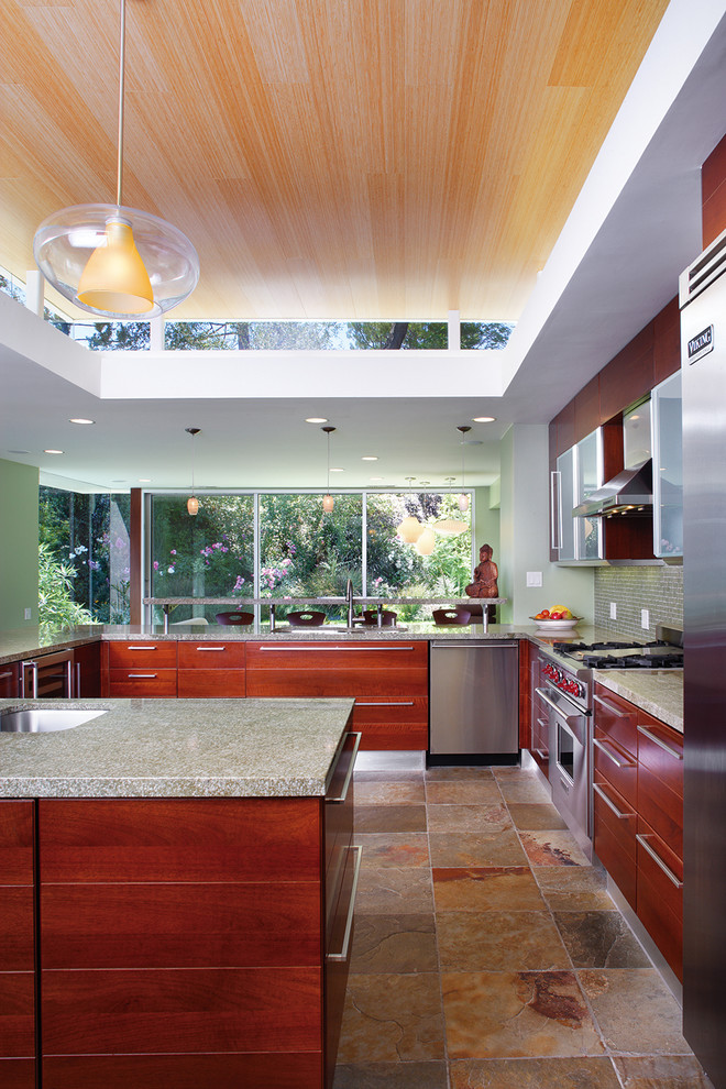 Inspiration for a mid-sized contemporary u-shaped open plan kitchen in Los Angeles with flat-panel cabinets, dark wood cabinets, stainless steel appliances, slate floors, granite benchtops, green splashback, glass tile splashback, with island and green benchtop.