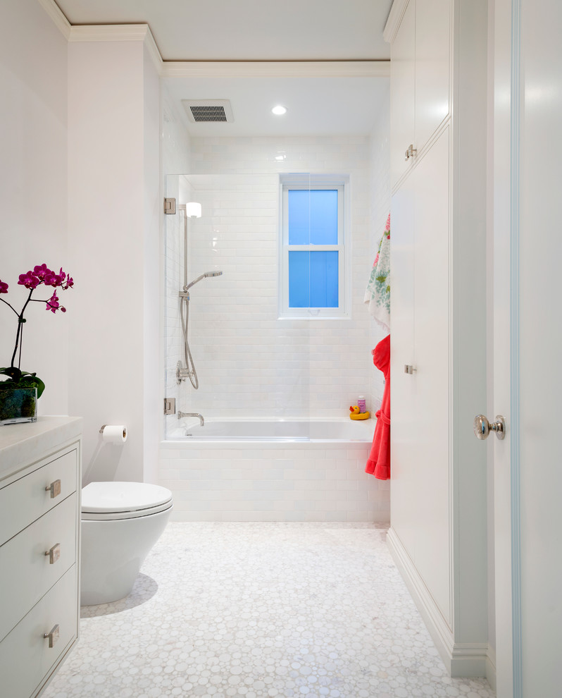 This is an example of a contemporary bathroom in San Francisco with flat-panel cabinets, white cabinets, an alcove tub, a shower/bathtub combo, white tile, subway tile and white floor.