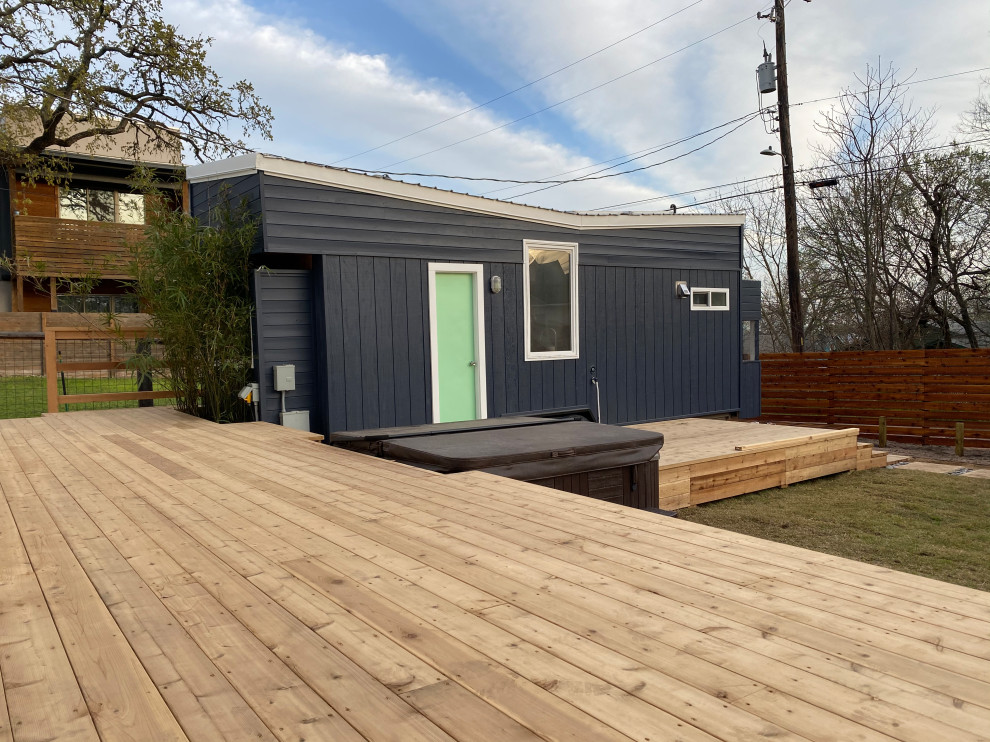 Идея дизайна: маленький, одноэтажный, синий мини дом в стиле кантри с облицовкой из винила, крышей-бабочкой, крышей из гибкой черепицы, черной крышей и отделкой дранкой для на участке и в саду