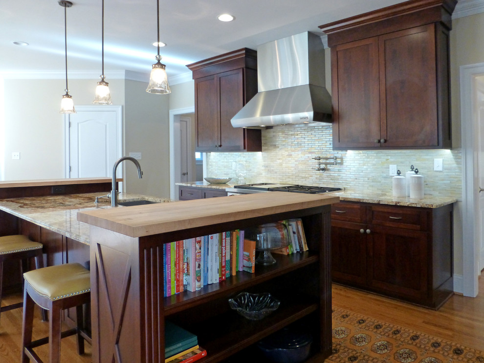 Large transitional medium tone wood floor kitchen photo in Richmond with recessed-panel cabinets, dark wood cabinets, granite countertops, beige backsplash, ceramic backsplash, stainless steel appliances and an island