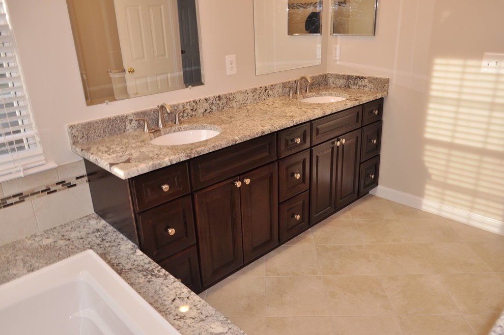 Drop-in bathtub - large transitional master beige tile and porcelain tile porcelain tile drop-in bathtub idea in DC Metro with a drop-in sink, raised-panel cabinets, dark wood cabinets, granite countertops and beige walls