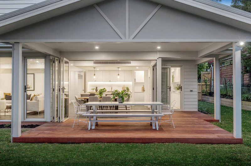 Cette image montre une grande terrasse arrière et au rez-de-chaussée minimaliste avec des solutions pour vis-à-vis et une extension de toiture.