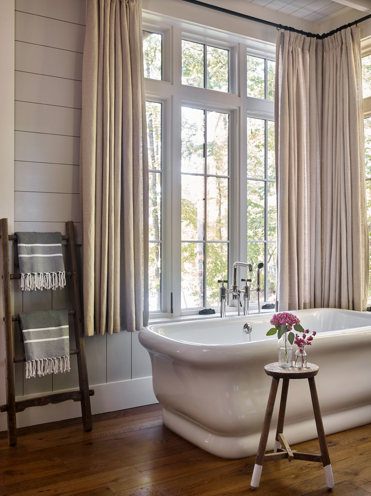 Design ideas for a country bathroom with a freestanding tub, grey walls, dark hardwood floors and brown floor.