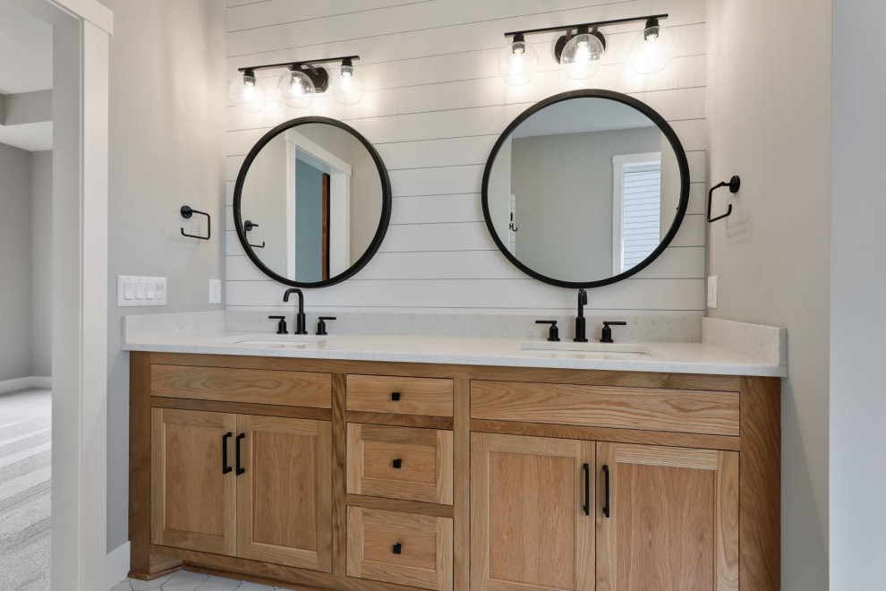 This is an example of a medium sized farmhouse ensuite bathroom in Minneapolis with beaded cabinets, grey walls, engineered stone worktops, white worktops, double sinks, a built in vanity unit and tongue and groove walls.