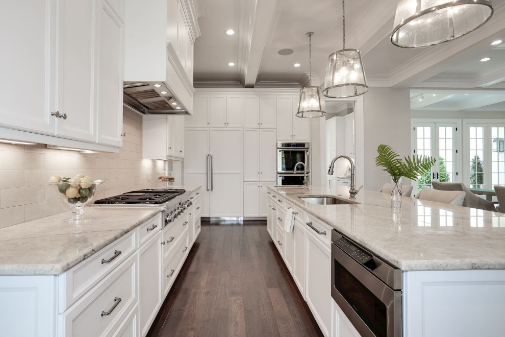 Large french country medium tone wood floor and coffered ceiling open concept kitchen photo in DC Metro with shaker cabinets, white cabinets, quartz countertops, paneled appliances, two islands and beige countertops