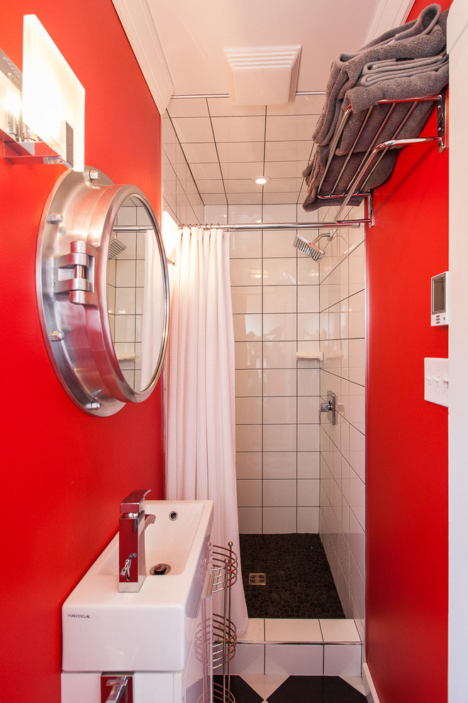 Photo of a small beach style bathroom in Other with an alcove shower, white tile, red walls and a console sink.