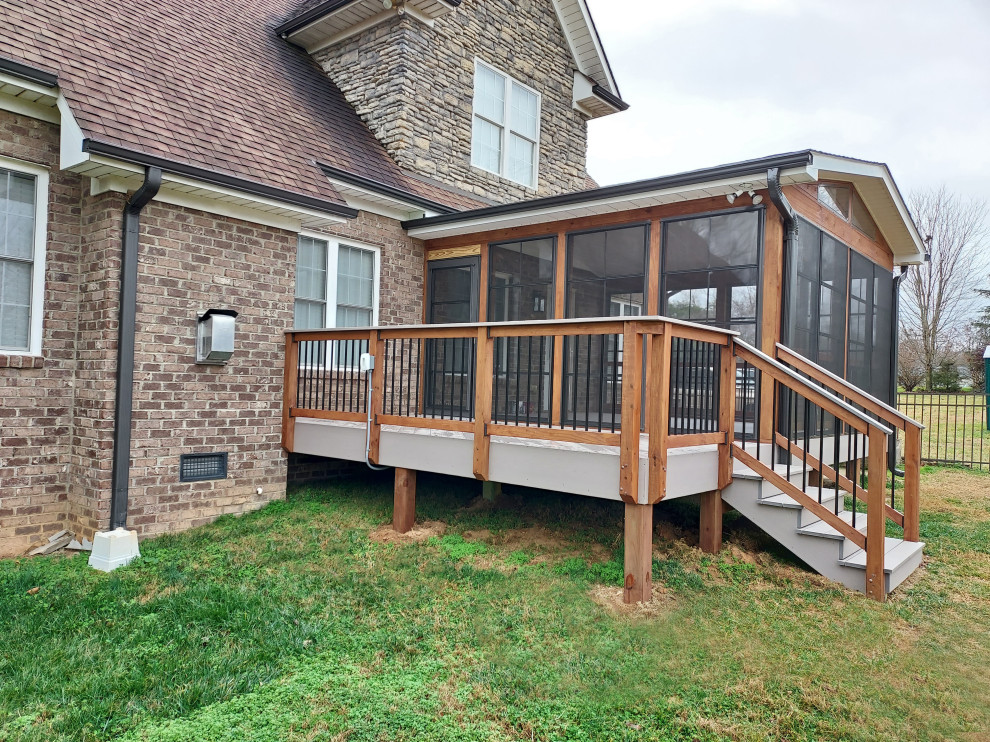 Exemple d'un porche d'entrée de maison arrière tendance de taille moyenne avec une moustiquaire, une extension de toiture et un garde-corps en matériaux mixtes.