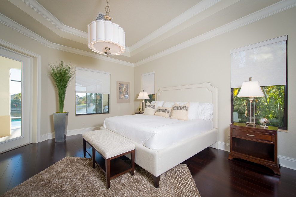 Inspiration for a tropical bedroom in Miami with beige walls and dark hardwood floors.