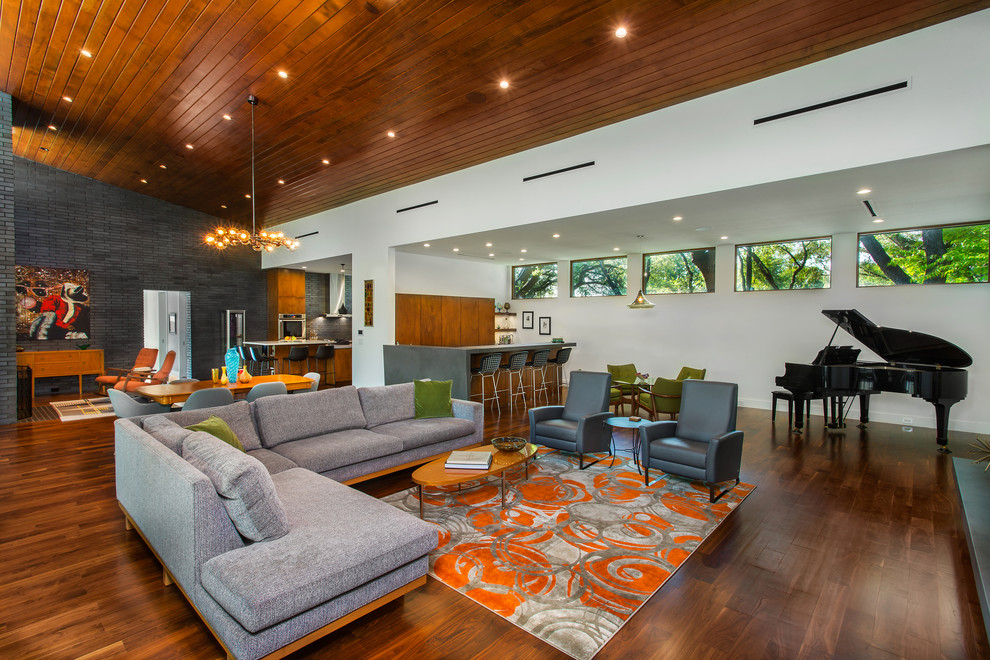 This is an example of a mid-sized midcentury open concept living room in Dallas with white walls, medium hardwood floors, brown floor and a music area.