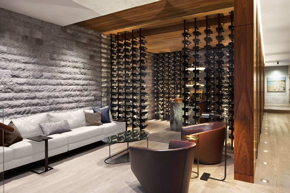 Inspiration for an expansive modern wine cellar in Seattle with light hardwood floors, storage racks and brown floor.