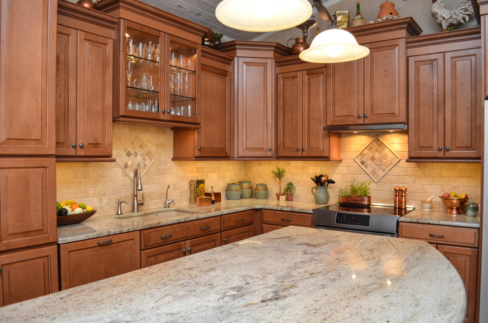 Inspiration for a mid-sized country l-shaped open plan kitchen in Tampa with an undermount sink, raised-panel cabinets, dark wood cabinets, limestone benchtops, beige splashback, stone tile splashback, stainless steel appliances, travertine floors and with island.