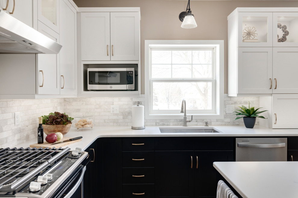 Eat-in kitchen - mid-sized transitional l-shaped medium tone wood floor and brown floor eat-in kitchen idea in Minneapolis with an undermount sink, recessed-panel cabinets, black cabinets, quartz countertops, beige backsplash, stone tile backsplash, stainless steel appliances, an island and white countertops