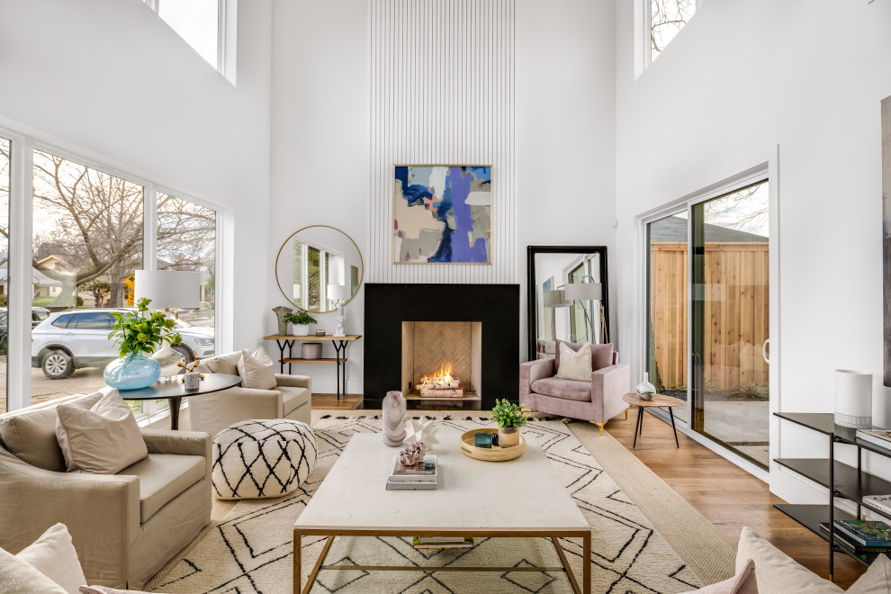 Inspiration for a large contemporary living room in Dallas with white walls, light hardwood flooring, a standard fireplace, a stone fireplace surround and brown floors.