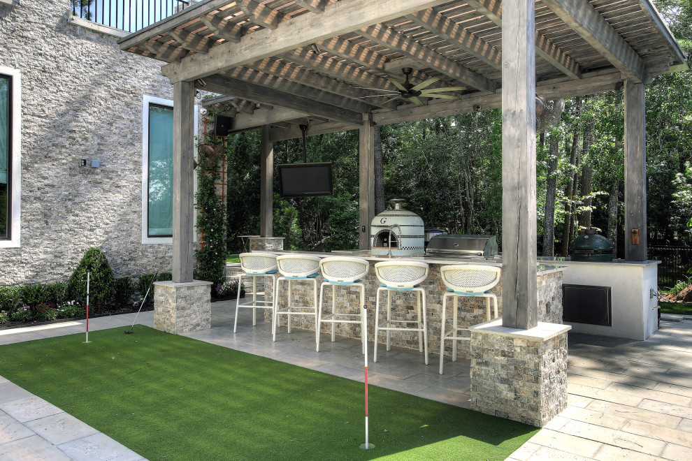 Photo of a contemporary backyard patio in Houston with an outdoor kitchen, concrete pavers and a pergola.