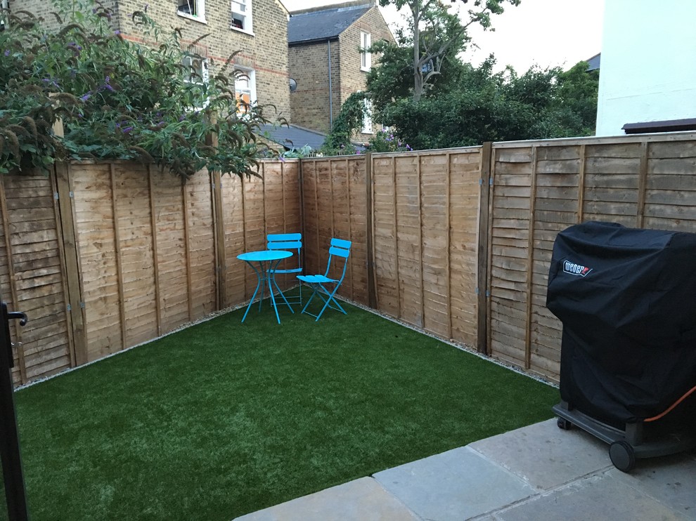 Photo of a small transitional backyard partial sun formal garden for summer in London with natural stone pavers.
