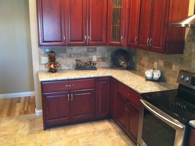 Inspiration for a large galley light wood floor enclosed kitchen remodel in Cedar Rapids with a drop-in sink, flat-panel cabinets, black cabinets, metallic backsplash and an island