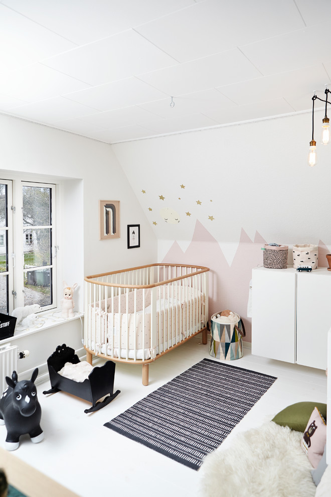 Contemporary nursery in Wiltshire with multi-coloured walls, painted wood floors and white floor for girls.