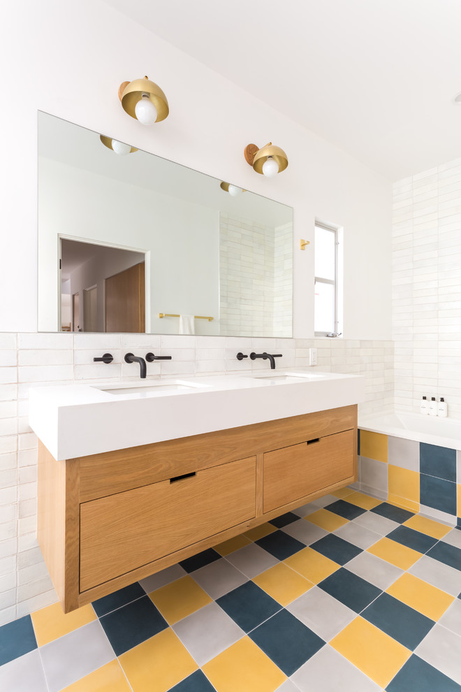 Design ideas for a mid-sized contemporary bathroom in Los Angeles with flat-panel cabinets, a drop-in tub, a one-piece toilet, white tile, ceramic tile, white walls, cement tiles, an undermount sink, engineered quartz benchtops, white benchtops, medium wood cabinets and multi-coloured floor.