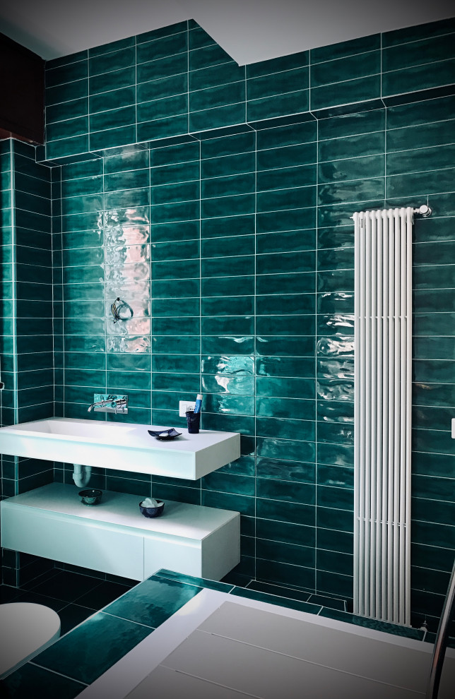 Idéer för mellanstora funkis vitt en-suite badrum, med vita skåp, ett undermonterat badkar, en kantlös dusch, en toalettstol med separat cisternkåpa, grön kakel, porslinskakel, klinkergolv i porslin, ett integrerad handfat, bänkskiva i akrylsten och grönt golv