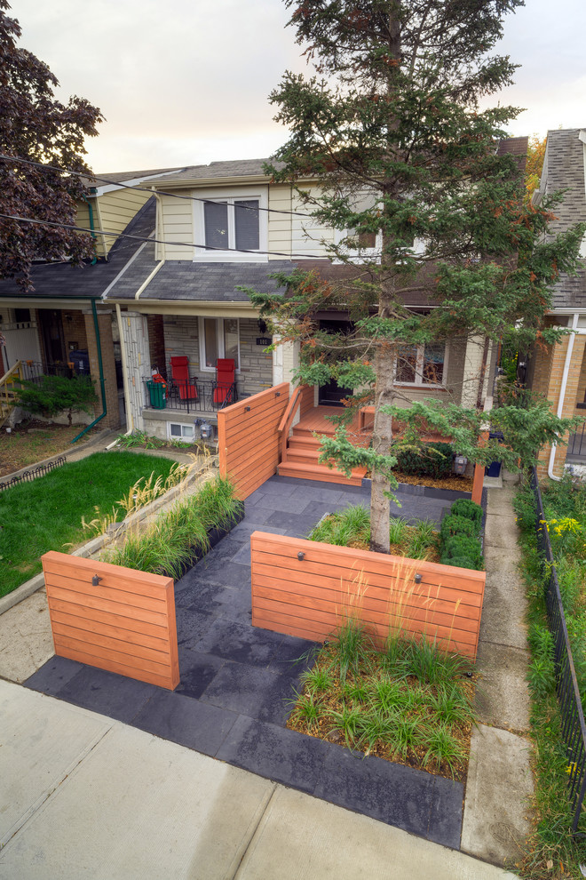 This is an example of a small modern front yard partial sun garden in Toronto with a garden path and natural stone pavers.
