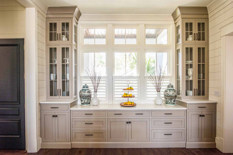 Eat-in kitchen - dark wood floor and brown floor eat-in kitchen idea with a farmhouse sink, beaded inset cabinets, beige cabinets, marble countertops, marble backsplash, stainless steel appliances and an island