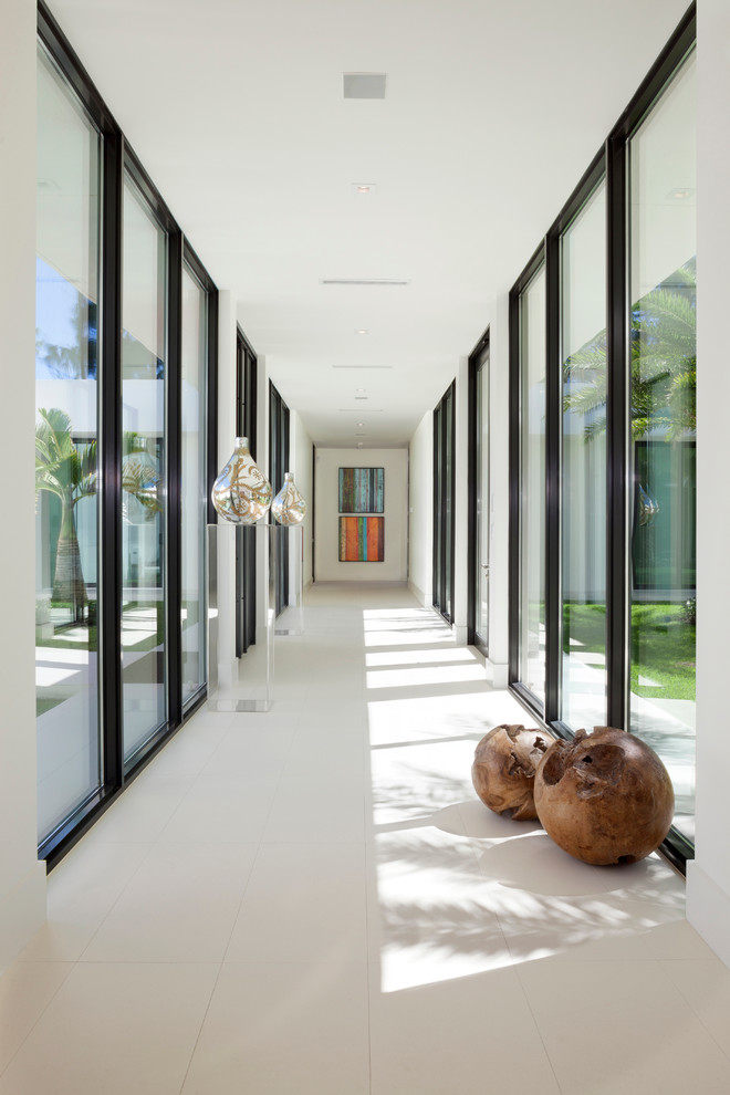 Photo of an expansive contemporary hallway in Miami with white walls, porcelain floors and white floor.