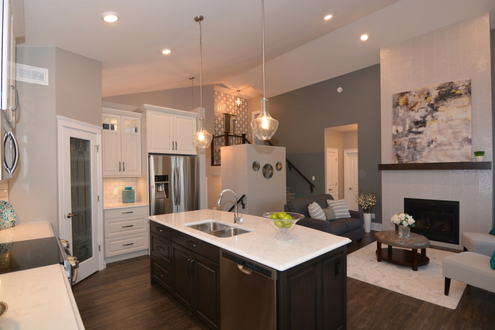 Inspiration for a mid-sized transitional l-shaped dark wood floor and brown floor open concept kitchen remodel with a double-bowl sink, raised-panel cabinets, dark wood cabinets, marble countertops, stainless steel appliances and an island