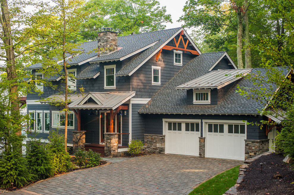 Photo of a country two-storey grey exterior in New York with wood siding.