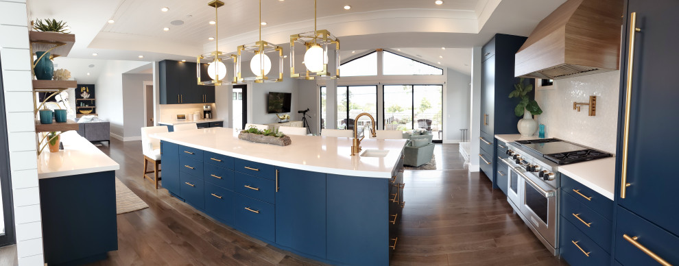 Example of a large minimalist u-shaped dark wood floor and brown floor open concept kitchen design with a farmhouse sink, flat-panel cabinets, blue cabinets, quartz countertops, white backsplash, mosaic tile backsplash, paneled appliances, an island and white countertops
