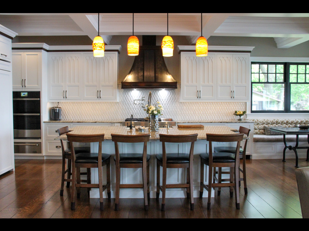 Inspiration for a large transitional l-shaped medium tone wood floor, brown floor and coffered ceiling open concept kitchen remodel with a farmhouse sink, recessed-panel cabinets, white cabinets, granite countertops, white backsplash, stainless steel appliances, an island and beige countertops