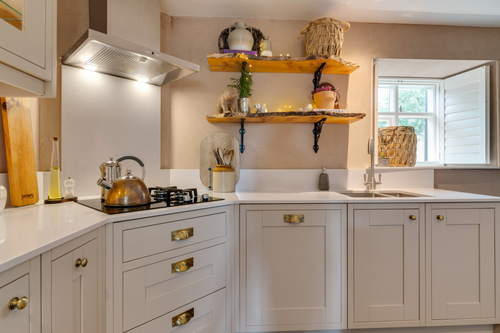 Small transitional u-shaped separate kitchen in Cheshire with an undermount sink, shaker cabinets, green cabinets, quartz benchtops, white splashback, engineered quartz splashback, stainless steel appliances, brick floors, a peninsula, multi-coloured floor and white benchtop.