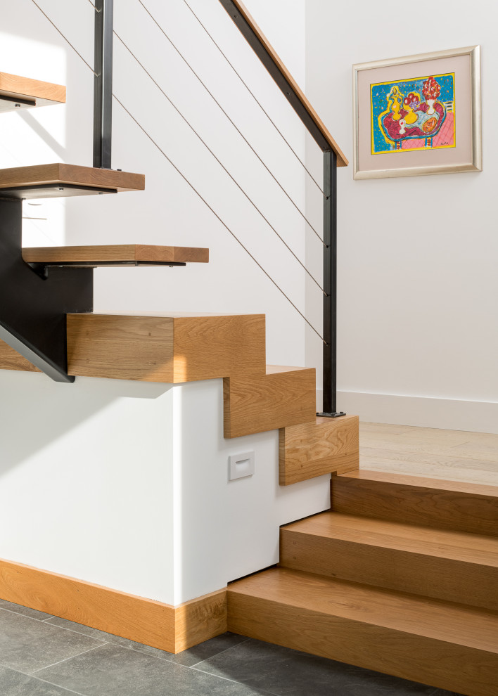 This is an example of a rural wood floating metal railing staircase in Burlington with metal risers.