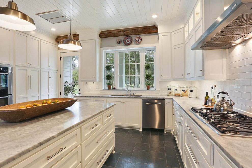 Transitional kitchen in New Orleans with an undermount sink, shaker cabinets, white cabinets, white splashback, subway tile splashback and with island.