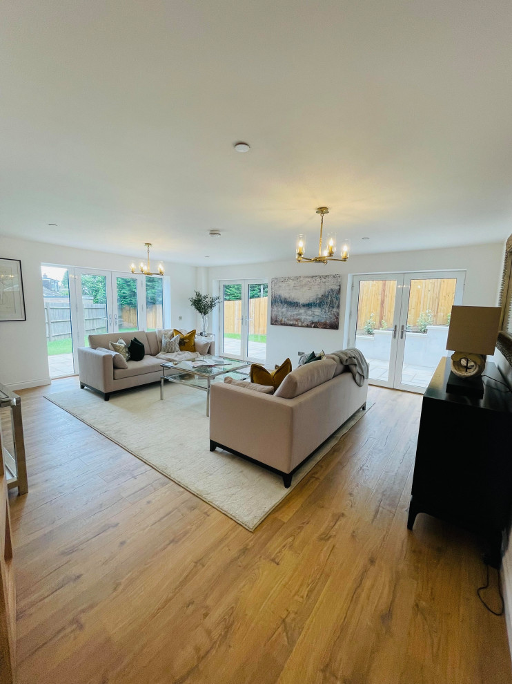 Photo of a large modern living room in Kent with white walls, light hardwood flooring and brown floors.