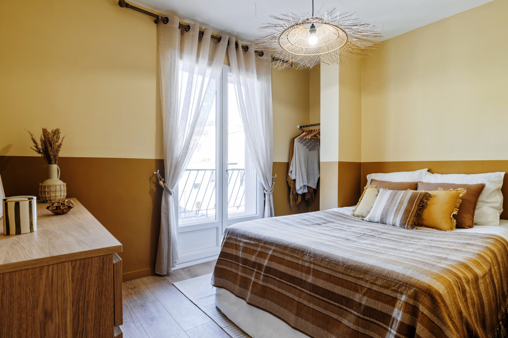 Diseño de dormitorio mediterráneo pequeño sin chimenea con paredes amarillas, suelo de madera clara y suelo beige