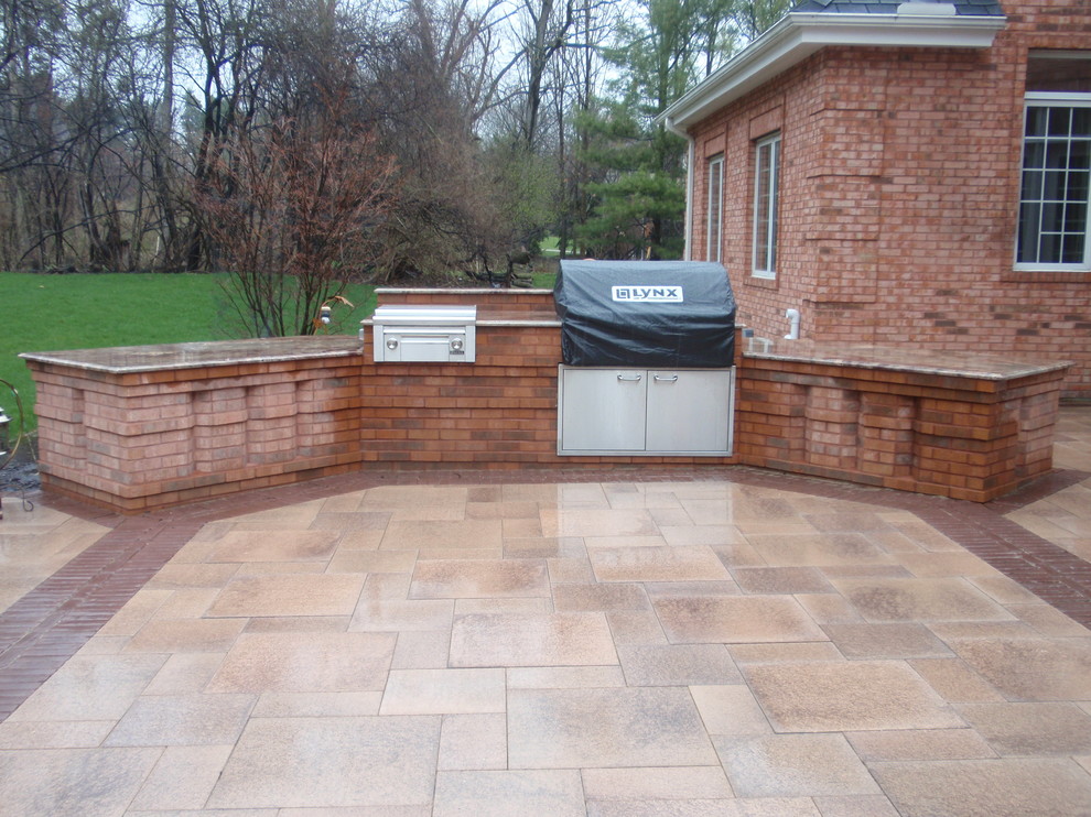 Photo of a mid-sized arts and crafts backyard patio in Detroit with an outdoor kitchen, concrete pavers and no cover.