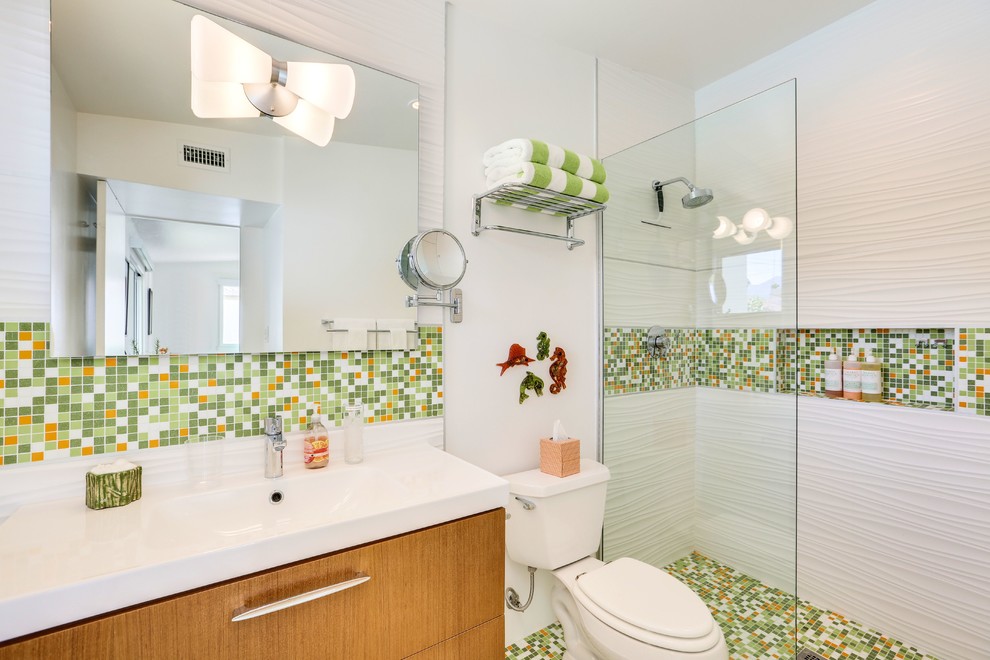 Midcentury 3/4 bathroom in Los Angeles with flat-panel cabinets, medium wood cabinets, an alcove shower, a two-piece toilet, multi-coloured tile, mosaic tile, white walls, mosaic tile floors, an integrated sink, multi-coloured floor and an open shower.
