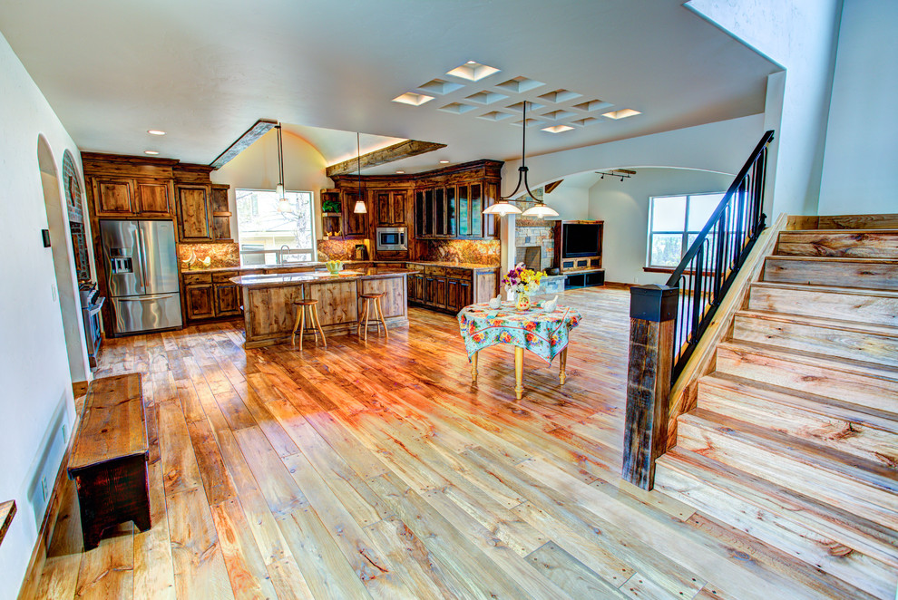 Large mountain style u-shaped medium tone wood floor kitchen pantry photo with a drop-in sink, glass-front cabinets, medium tone wood cabinets, beige backsplash, stainless steel appliances and an island