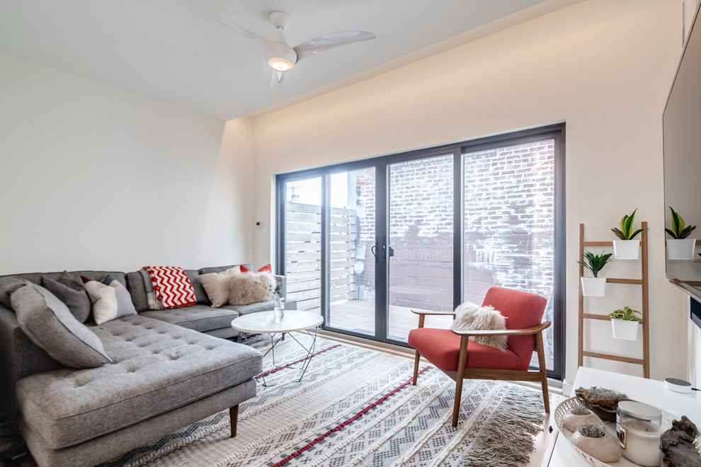 Example of a small minimalist open concept light wood floor and beige floor living room design in Philadelphia with white walls, no fireplace and a wall-mounted tv