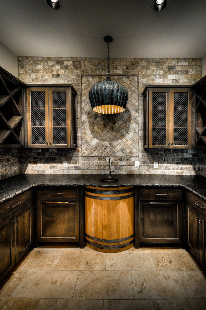 Photo of a large country u-shaped wet bar in Austin with an undermount sink, recessed-panel cabinets, dark wood cabinets, quartz benchtops, brown splashback, stone tile splashback, travertine floors and brown floor.