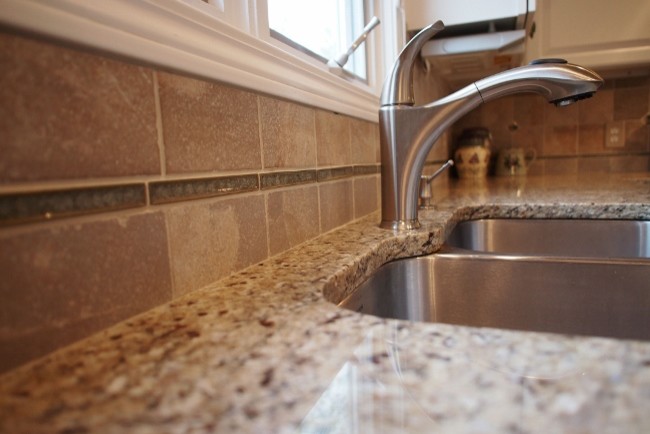 Photo of a traditional kitchen in Grand Rapids with an undermount sink, granite benchtops, beige splashback and ceramic splashback.