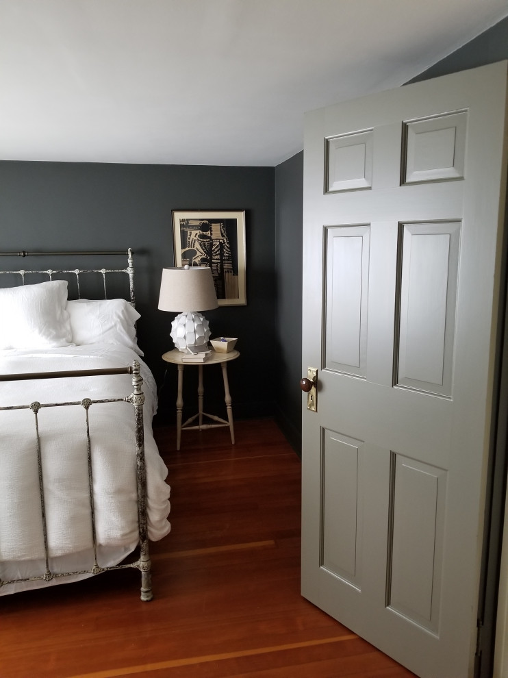 Inspiration for a small country master bedroom in New York with grey walls, medium hardwood floors, no fireplace and brown floor.