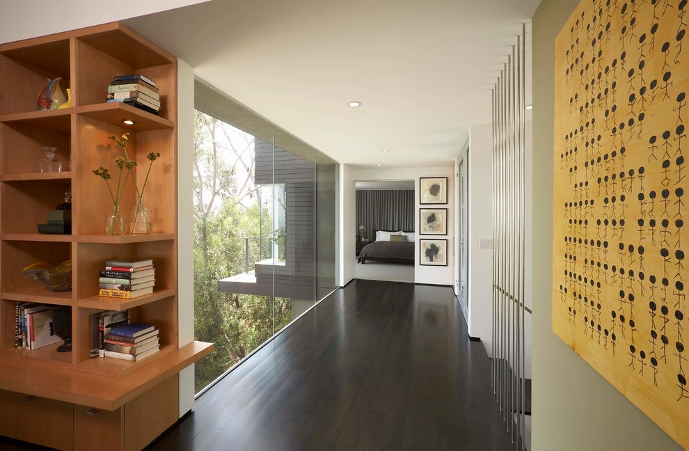 This is an example of a contemporary hallway in Los Angeles with white walls and dark hardwood floors.