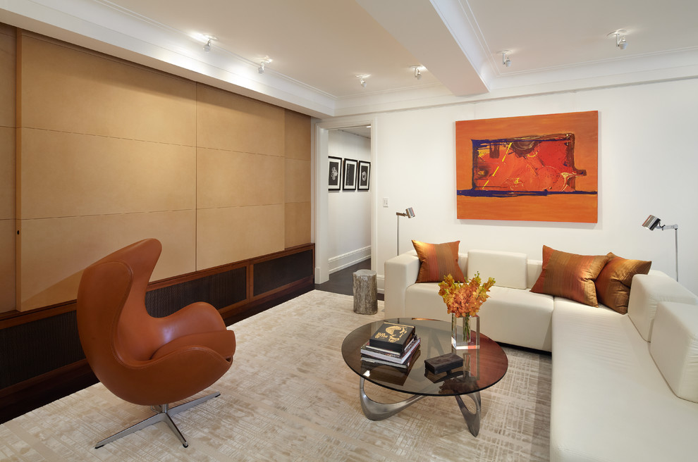 This is an example of a mid-sized transitional open concept family room in New York with medium hardwood floors, no fireplace, a concealed tv and white walls.