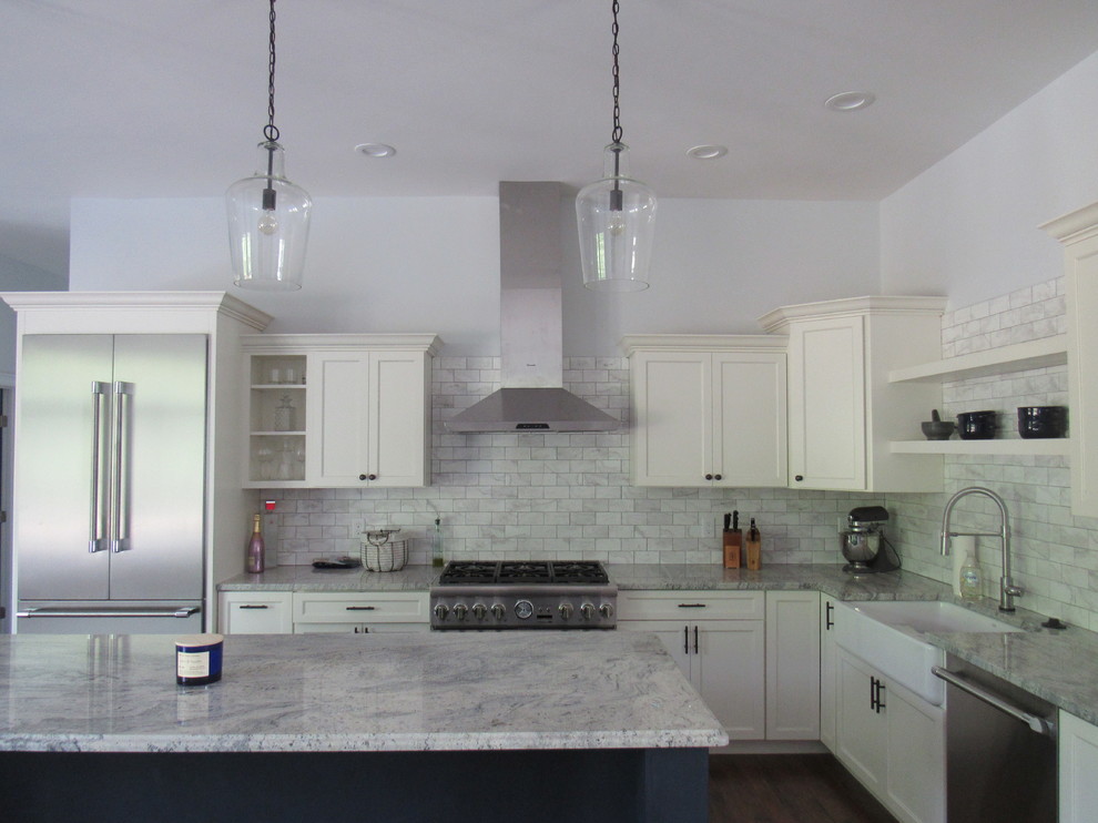 This is an example of a mid-sized contemporary l-shaped eat-in kitchen in Boston with a farmhouse sink, shaker cabinets, white cabinets, granite benchtops, grey splashback, stone tile splashback, stainless steel appliances, dark hardwood floors, with island, brown floor and blue benchtop.